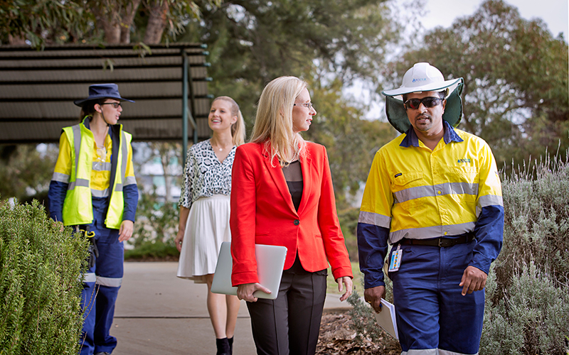 A group of employees at Water Corporation walk and talk outside together